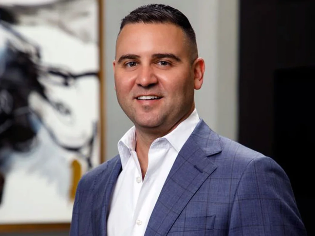 Misha Ezratti, President of GL Homes, standing in front of a luxury residential community in Florida